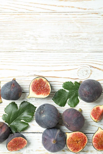 Fig with leaves on white wooden background
