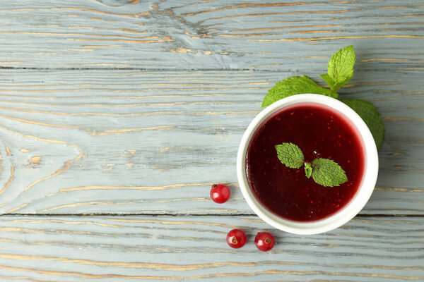 Bowl of cranberry sauce on gray wooden background