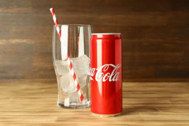 Odessa, Ukrayna - 23 Eylül 2021: Coca - kola kutusu ve ahşap masa üzerinde buzlu ve samanlı cam.