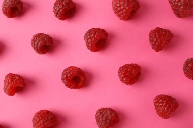 Pembe arka planda kırmızı sulu ahududu ile düz kompozisyon