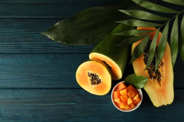 Tahta masa üzerinde yaprakları olan taze papaya, metin için boşluk