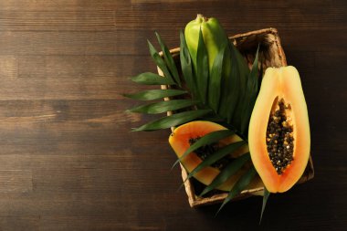 Tahta masada papaya olan sepet.