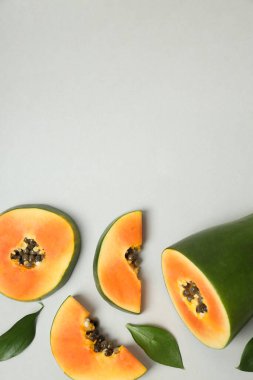 Açık gri zemin üzerinde papaya ile düz yatıyordu