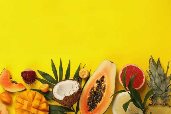 Exotic fruits set on yellow background, space for text.