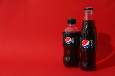 Odessa, Ukrayna - 23 Eylül 2021: Kırmızı arka planda Pepsi şişeleri..