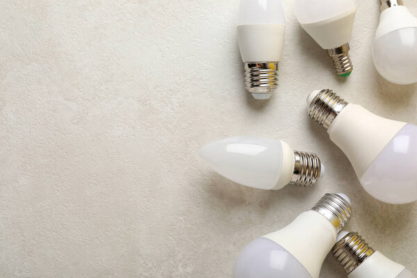 Energy saving bulbs on white textured background.