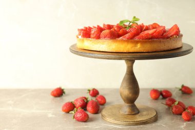 Gri desenli masada çilekli turta ile ahşap tezgah..