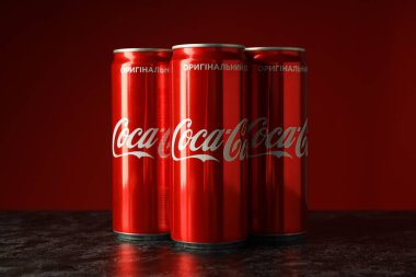 Odessa, Ukrayna - 23 Eylül 2021: Coca - Kırmızı arka plana karşı kola kutuları