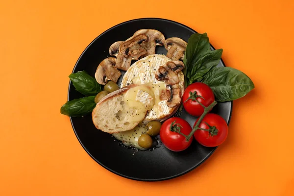 Turuncu arka planda ızgara camembert ile lezzetli yemek kavramı.