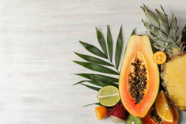 Beyaz ahşap zemin üzerinde egzotik meyveler, metin için boşluk.