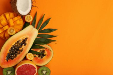 Turuncu arkaplanda egzotik meyveler, metin için boşluk.