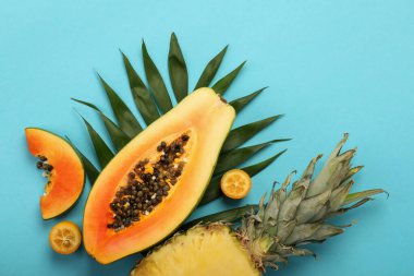 Mavi arka planda olgun taze egzotik meyveler.