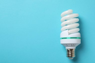 Mavi arkaplanda enerji tasarrufu ampulü, metin için boşluk.