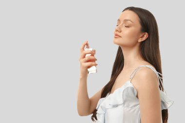 Kadın evde parfüm sürerken rahatlatıcı bir an yaşıyor.