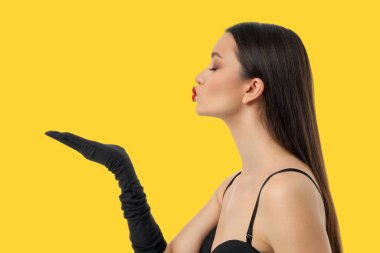 Siyah bluzlu kadın ve öpücük yollayan eldivenler.