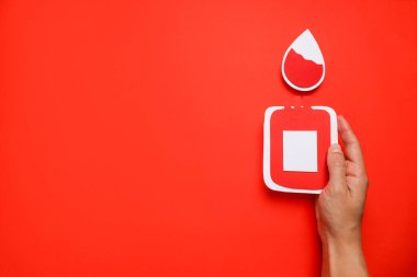 Elinde kan bağışını temsil eden bir kağıt kesiği var.