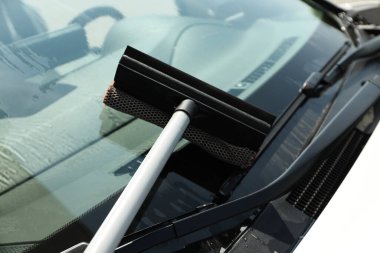 Araç istasyonda yakıt ikmali yaparken ön cam temizleniyor.