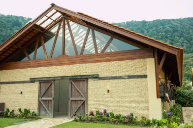 Büyük pencereli ve ahşap detaylı kırsal yapı