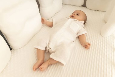 Tatlı bebek huzurlu bir çocuk odasında yumuşak bir yatak üzerinde dinleniyor.