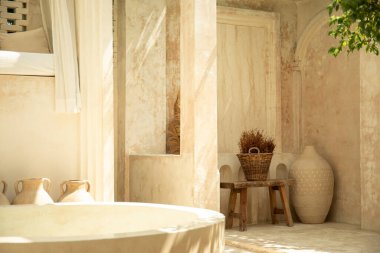 Doğal taş duvarları, damarları ve güneş ışığıyla sakin bir avlu.