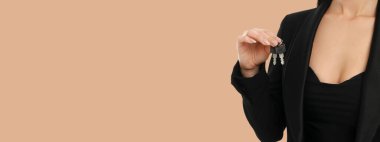 Siyah takım elbiseli genç bir kadında anahtar var.