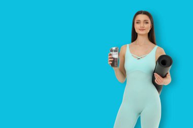 Yoga aktivitesi, stüdyoda su ve minder tutan birini gösteriyor.