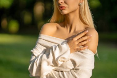 Doğal ışık altında omuz üstü giyinen model.