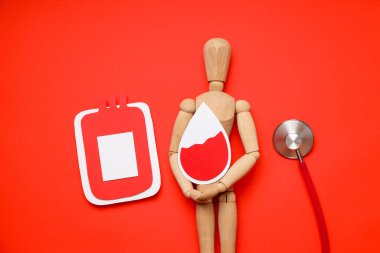 Kırmızı arka planda kan damlası ve poşeti olan manken.