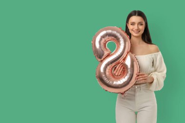 Kadınlar Günü için 8 numaralı balonu tutan kadın.