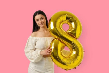 Genç bir kadın 8 numara şeklinde altın bir balon tutuyor.