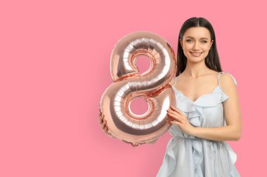 8 şeklinde büyük bir balonla gülümseyen bir kadın.