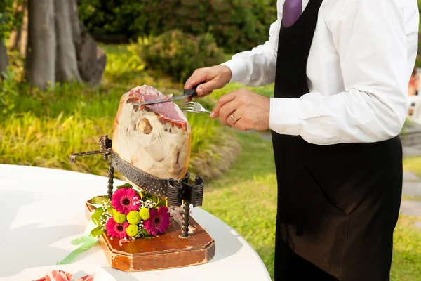 Chef slices raw ham — Stock Photo, Image