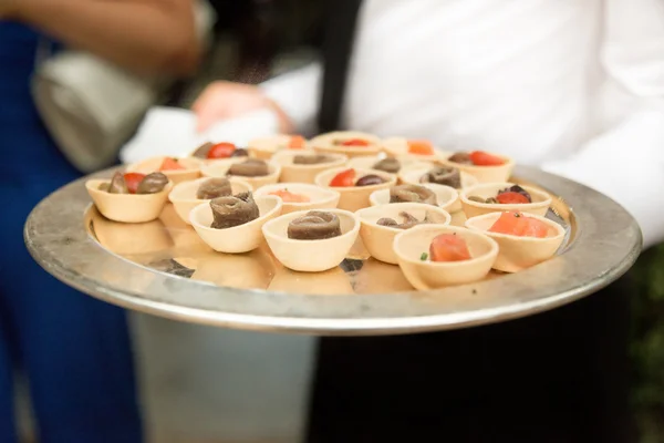 Cameriere che porta antipasti e finger food — Foto Stock