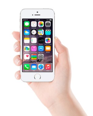 Elma gümüş iphone 5'ler görüntülenirken IOS 8 tasarlanmış kadın elinde