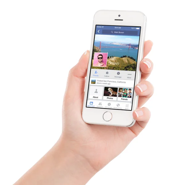 Γυναικείο χέρι που κρατά το λευκό iphone της Apple 5s με Facebook app — Φωτογραφία Αρχείου