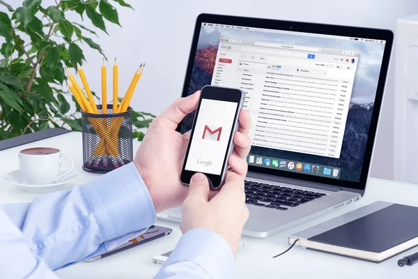 Gmail uygulaması iphone üzerinde görünen adam ellerini ve Macbook Pro ekran