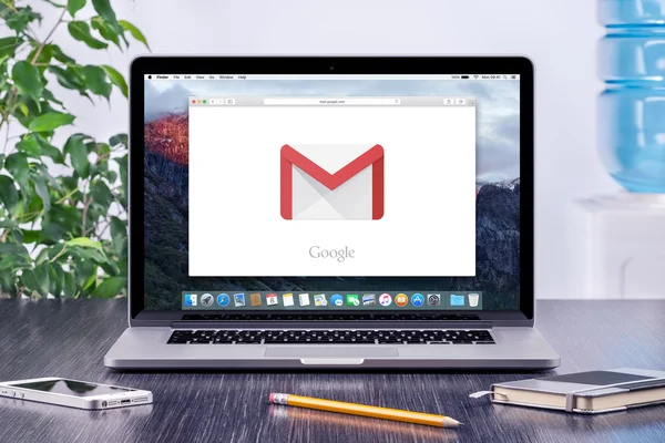 Google Gmail logo on Apple MacBook display in office workplace — Stock Photo, Image