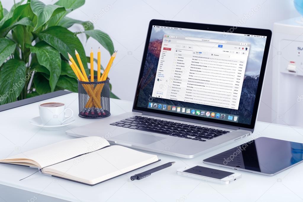 Varna, Bulgaria - May 29, 2015: Google Gmail email inbox interface on the Apple MacBook Pro screen that is on office desk. Gmail is a free email service provided by Google. All gadgets in focus.