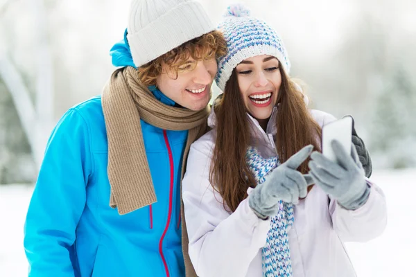 Winterpaar mit Handy — Stockfoto