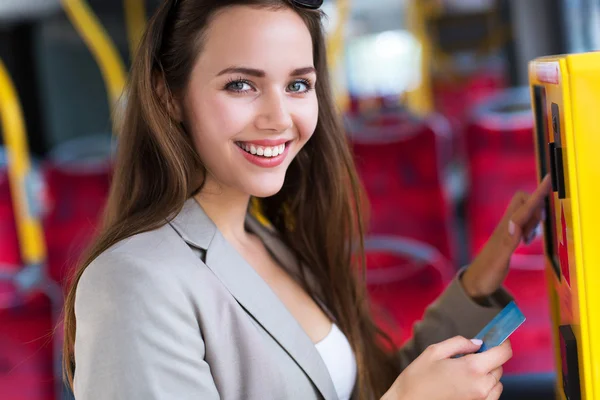 Mujer usando máquina expendedora de billetes en autobús — Foto de Stock