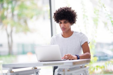 Laptop kullanan afro adam.