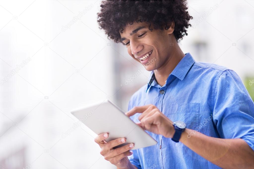 Man with afro holding digital tablet