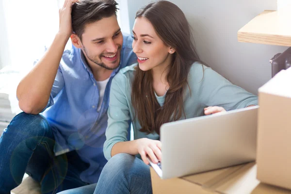 Couple with unpacked boxes in new home — Stock Photo, Image