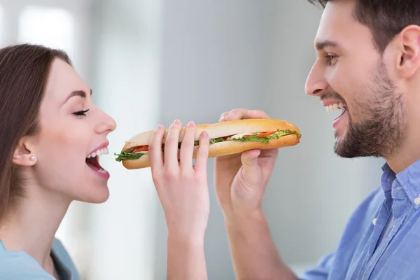 Casal compartilhando sanduíche — Fotografia de Stock