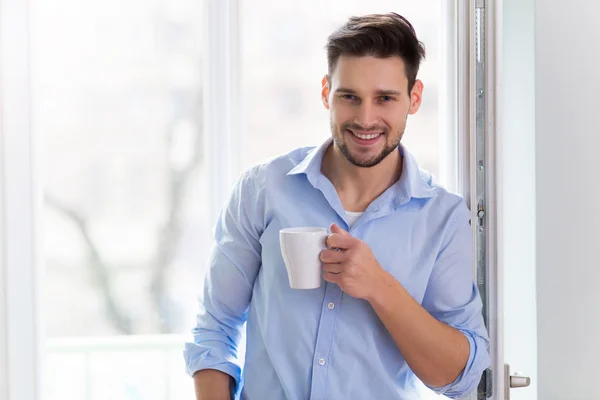 Homem bebendo xícara de café perto da janela — Fotografia de Stock