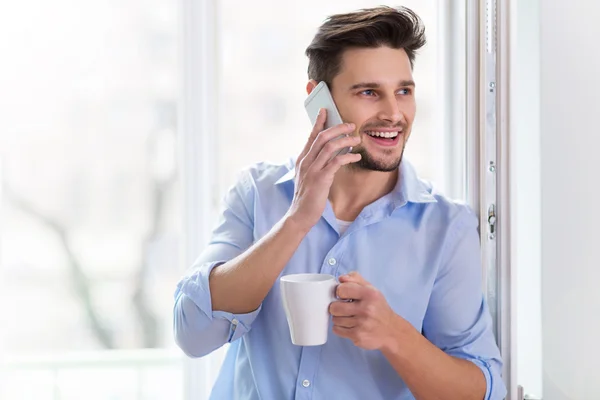 Homem usando telefone celular em casa — Fotografia de Stock