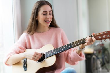 Gitar çalan genç kadın