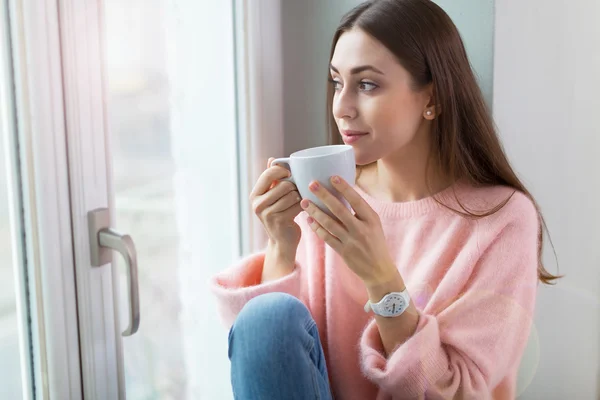 Woman drinking coffee near window — Stock Photo, Image