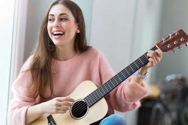 Jovem mulher tocando guitarra — Fotografia de Stock