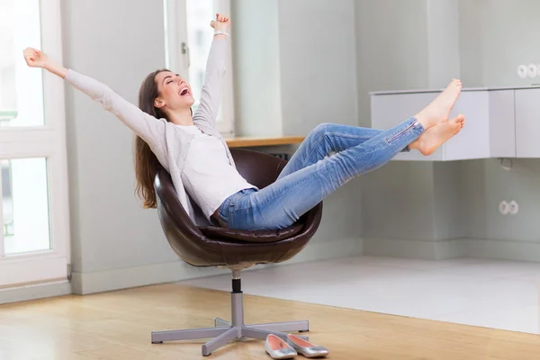 Woman sitting in armchair, arms outstretched — Stock Photo, Image